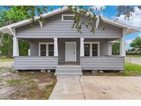 Charming gray home with inviting front porch, white trim, and well-maintained landscaping at 630 Pear St, Lakeland, FL 33815