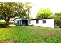 Charming home featuring a lush green lawn and mature trees, offering a serene and inviting curb appeal at 808 S Clara Ave, Deland, FL 32720