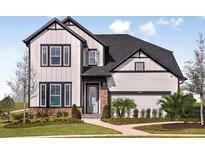 Charming two-story home boasts a modern farmhouse design and well-manicured lawn with sidewalk leading to front door at 17020 Cercis Loop, Clermont, FL 34711
