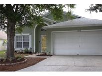 Charming one-story home with a well-maintained lawn and attached two-car garage at 1048 Winding Water Way, Clermont, FL 34714