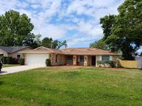Charming single-story home with a well-maintained lawn and attached garage at 2414 Willow Oak Dr, Edgewater, FL 32141