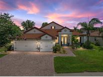 Charming home featuring a three-car garage, lush landscaping, and a brick paved driveway at 3939 Sunset Lake Dr, Lakeland, FL 33810