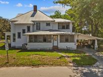 Charming multi-story home featuring a metal roof, inviting front porch, and convenient covered parking area at 485 E Stanford St, Bartow, FL 33830