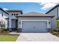Charming home featuring a gray garage door, stone accents and a well maintained lawn at 7890 Somersworth Dr, Kissimmee, FL 34747