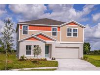Two-story home featuring a two-car garage, neutral paint, and a well-manicured lawn at 1617 Sage Ave, Haines City, FL 33844