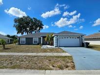 Charming single-story home with a well-manicured lawn, a two car garage, and a nicely painted exterior at 205 Golf Aire Blvd, Haines City, FL 33844
