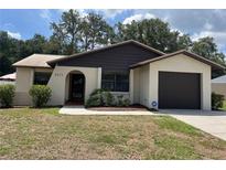 Charming single-story home with a well-maintained front yard and an attached garage at 2271 Crystal Grove Ln, Lakeland, FL 33801