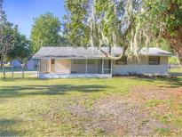 Charming single-story home with a screened porch and lush green lawn at 3550 Keen Dr, Mulberry, FL 33860