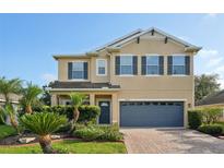 Inviting two-story home with a well-manicured lawn, brick driveway, and covered entryway at 3848 Spirited Cir, St Cloud, FL 34772