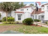 Home featuring green landscaping, a red tile roof, white stucco, and a black flag at 2524 Albion Ave, Orlando, FL 32833
