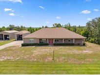 Expansive ranch-style home with brick accents and a spacious, well-maintained front yard, perfect for suburban living at 14365 Evans Ranch Rd, Lakeland, FL 33809