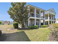 Spacious two-story home with a large yard and elegant, column-supported balconies at 7523 Excitement Dr, Kissimmee, FL 34747