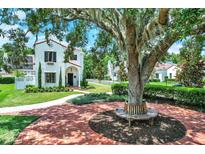 Charming home with large tree and circular brick patio and walkway to entrance at 740 Oak Shadows Rd, Kissimmee, FL 34747