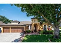 Charming single-story home with a terracotta roof, manicured landscaping and a two-car garage at 790 Country Charm Cir, Oviedo, FL 32765