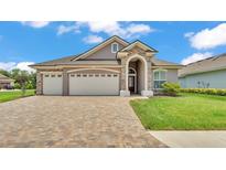 Charming single-story home featuring a three-car garage, manicured lawn, and stone accents at 7890 Lake James Blvd, Lakeland, FL 33810