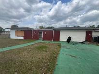 Modest, single story home with brick and siding, shows boarded window, and basketball hoop at 801 Quintilian Ave, Orlando, FL 32809