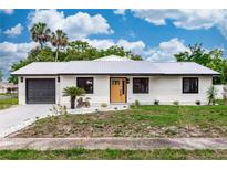 Charming home featuring a metal roof, freshly painted exterior, updated landscaping and an attached garage at 1161 Orangewood Ave, Deland, FL 32724
