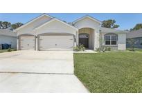 Charming single-story home featuring a three-car garage, well-manicured lawn, and beautiful front entrance at 229 St Thomas Dr, Mulberry, FL 33860