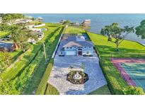 Stunning waterfront home with well manicured grounds, spacious driveway, water access and pool and tennis court at 390 Windermere Dr, Lakeland, FL 33809