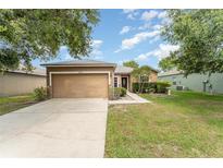 Charming single-story home features a well-maintained lawn, a two-car garage, and beautiful landscaping at 6898 Glenbrook Dr, Lakeland, FL 33811
