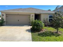 Inviting single story home featuring an attached garage and manicured lawn at 1509 Venice Ln, Davenport, FL 33896