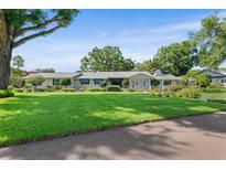 Charming home with well-manicured front yard and mature trees providing shade, enhancing its curb appeal at 2110 Reaney Rd, Lakeland, FL 33803