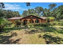 Inviting single-story home with arched entry, mature landscaping, and a well-manicured lawn at 1625 Itchepackesassa Dr, Lakeland, FL 33810