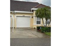 Charming home features a one-car garage and well-maintained landscaping with a palm tree at 2202 Garden Lake Dr, Winter Haven, FL 33884