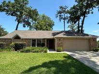 Charming single-story home with a well-manicured lawn, mature trees, and an attached two-car garage at 2921 Se 38 Pl, Ocala, FL 34480