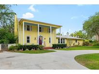 Charming yellow two-story home with a covered front porch, lush landscaping, and a welcoming driveway at 1226 Se 9Th Ave, Ocala, FL 34471