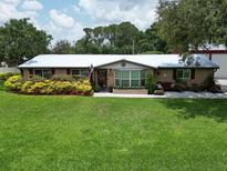 Charming single-story home featuring a lush front lawn and beautiful landscaping at 1423 Spruce N Rd, Lakeland, FL 33809