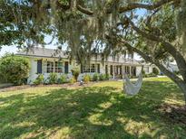 Charming home with lush lawn, brick accents, and a relaxing hammock hanging from a tree at 3100 Peacock Ln, Mulberry, FL 33860