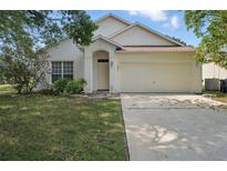 Charming single-Gathering home features a two-car garage, well-manicured lawn, and neutral exterior paint at 442 Graystone Blvd, Davenport, FL 33837
