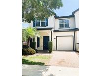 Charming home featuring brick drive, one car garage, blue shutters, and beautifully manicured lawn at 10303 Park Commons Dr, Orlando, FL 32832