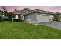 Charming home featuring a well-manicured lawn, a gray exterior, and a convenient two-car garage at 7991 Lake James Blvd, Lakeland, FL 33810
