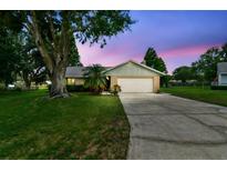 Well-maintained home with a two-car garage and a spacious driveway at dusk at 4221 Meadowbend Ct, Lakeland, FL 33811