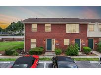 Two-story brick townhouse with lush landscaping and parking spaces in front at 1920 E Edgewood Dr # E1, Lakeland, FL 33803