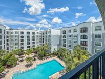 Expansive view of the community pool surrounded by lush tropical landscaping and resort-style amenities at 202 E South St # 5050, Orlando, FL 32801