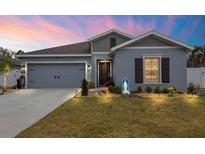 Charming single-story home with manicured lawn, rock garden and a two-car garage at 389 Singing Sands Cir, Lake Wales, FL 33859
