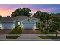 Charming home featuring a two-car garage, beautiful landscaping, and a brick driveway at 1890 Flora Pass Pl, Kissimmee, FL 34747