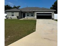 Charming single-story home with a well-manicured lawn and a spacious driveway leading to an attached garage at 15094 Sw 43Rd Avenue Rd, Ocala, FL 34473
