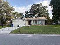 Charming single-story home with a well-maintained front yard, driveway, and attached garage at 2123 Woodburn S Loop, Lakeland, FL 33813