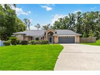 Charming brick home with well-manicured lawn and mature landscaping at 722 Swaying Palm Dr, Apopka, FL 32712