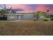 Charming single-story home featuring a gray brick exterior and manicured landscaping against a vivid sunset backdrop at 837 E Edgewood Dr, Lakeland, FL 33803