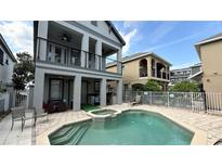 Resort style pool area featuring a spa, putting green, covered patio, and fenced yard perfect for outdoor living at 7810 Whitemarsh Way, Reunion, FL 34747
