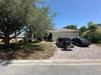 Charming single-story home featuring a two-car garage and a brick driveway with a beautifully landscaped front yard at 1920 Eloise Cove Dr, Winter Haven, FL 33884