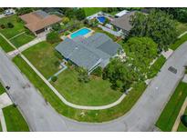 Gorgeous aerial view of home with beautiful lawn, swimming pool, and mature trees at 107 Elm N Sq, Lakeland, FL 33813
