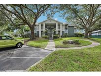 Inviting condo exterior with a beautifully landscaped lawn and mature trees at 731 Sugar Bay Way # 205, Lake Mary, FL 32746