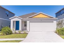 Charming single-Gathering home with a bright blue front door and attached two car garage at 766 Ambleside Dr, Haines City, FL 33844