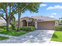 Charming single-story home with a well-manicured lawn, mature trees, and a two-car garage at 433 Woodcrest St, Winter Springs, FL 32708